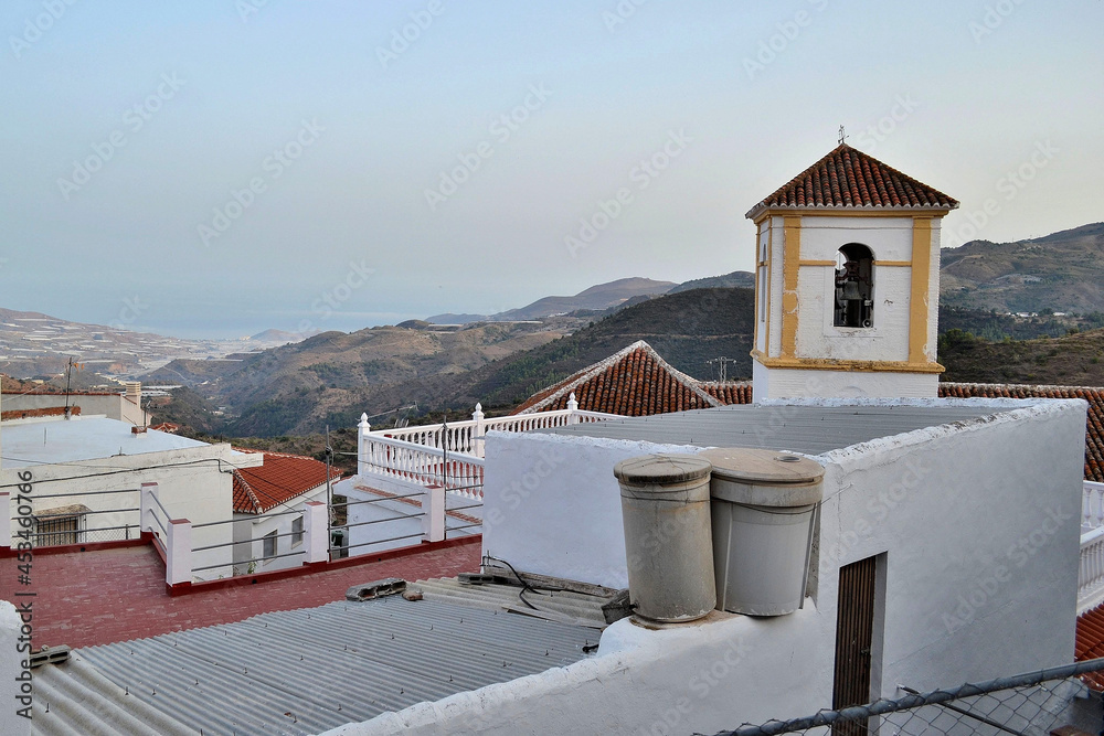 Lujar church tower and houses with the sea in the background