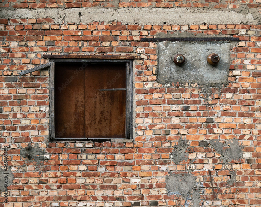 old brick wall of a building with a closed iron window old brick wall of a building with a closed iron window