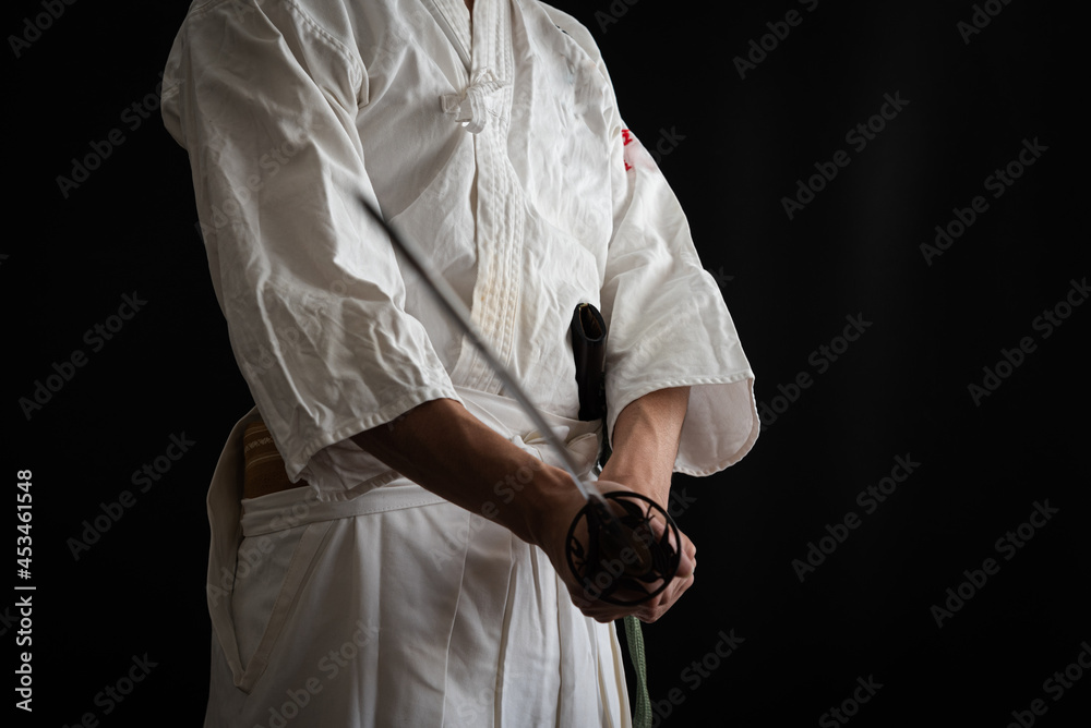 Obraz premium 黒い背景と日本刀を構える人物