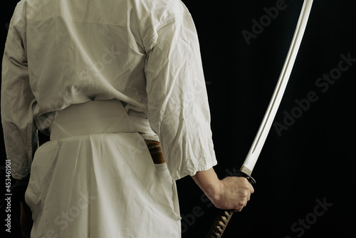 黒い背景と日本刀を構える人物
