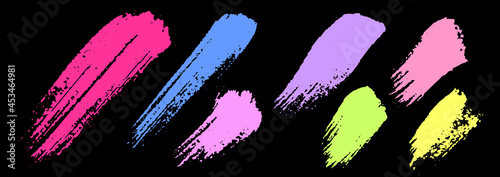 Set of colorful brush strokes. Dirty grunge texture. Different grunge brush strokes. Dirty artistic design elements isolated on black background. Neon colorful ink. Vector illustration