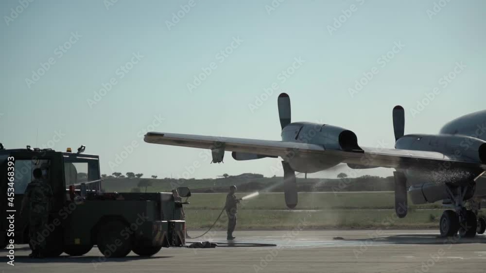 An American military aircraft, with an emergency landing after an accident and overheating of the engines. The assistant pours water on the heated motors. An American military aircraft, with an emergency landing after an accident and overheating of the engines. The assistant pours water on the heated motors.