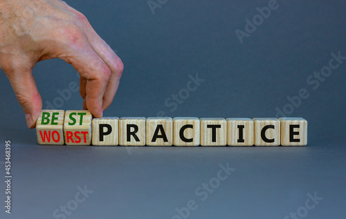 Best or worst practice symbol. Businessman turns wooden cubes and changes words 'worst practice' to 'best practice'. Beautiful grey background. Business, best or worst practice concept. Copy space. photo