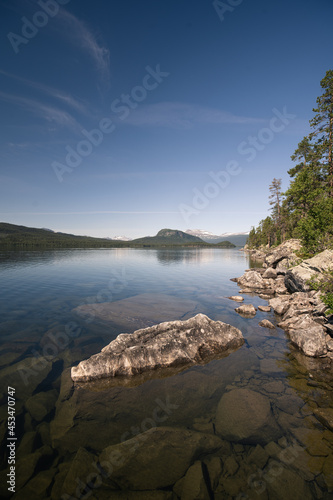 kristal klarer bergsee irgendwo in schwedens natur mit blauem himmel und vereinzelten wolken. © thomas