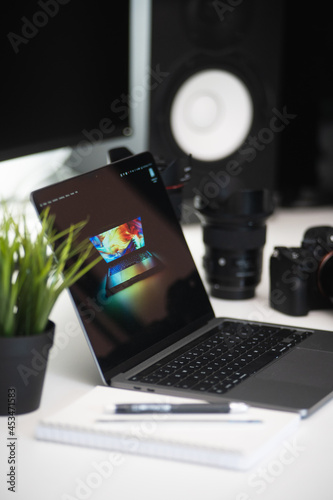 minimalistisches Homeoffice eines Fotografen mit einer grünen pflanze Kamera und objektiven