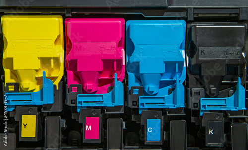 The photo shows an open printer with a view of the colored toner cartridges