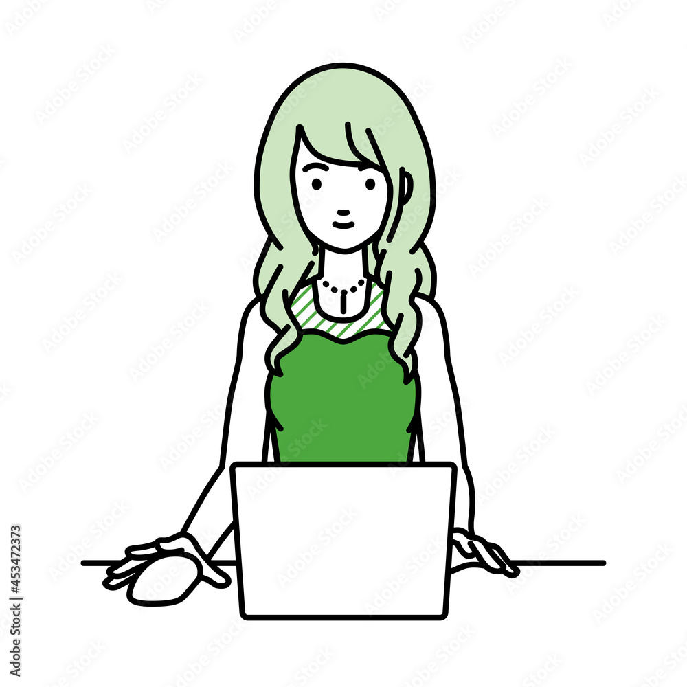 デスクで座ってPCを使っているドレスの女性