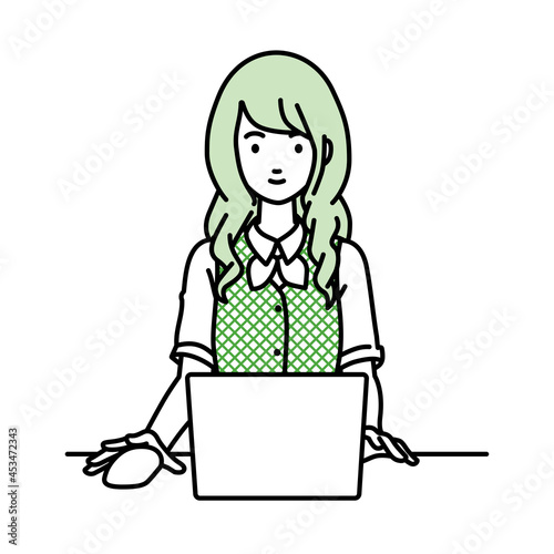デスクで座ってPCを使っている事務員制服の女性