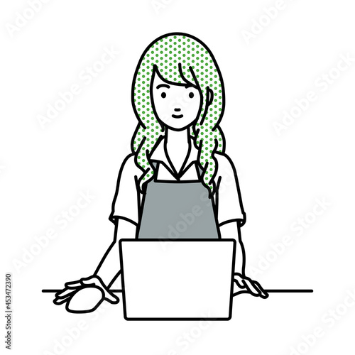 デスクで座ってPCを使っているカフェ店員の女性