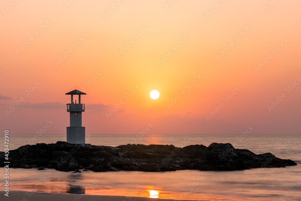Khao Lak light beacon or lighthouse for navigation on rock near beach during sunset, famous travel destination and resort near Phuket, Phang-Nga, Thailand