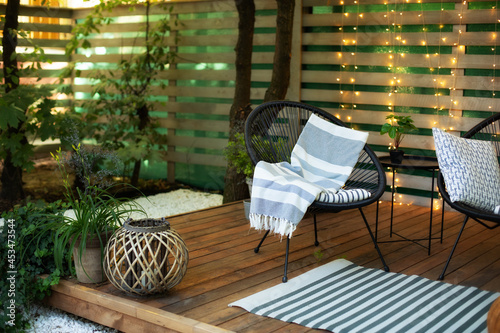 Fototapeta Exterior veranda of house with black Acapulco armchairs and plants pots