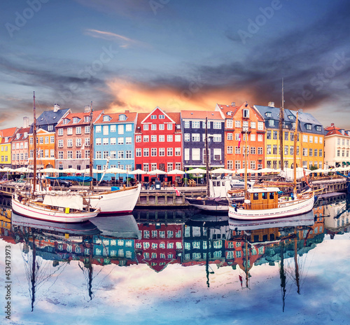 Breathtaking beautiful scenery with boats in the famous Nyhavn in Copenhagen, Denmark at sunrise. Exotic amazing places. Popular tourist atraction.