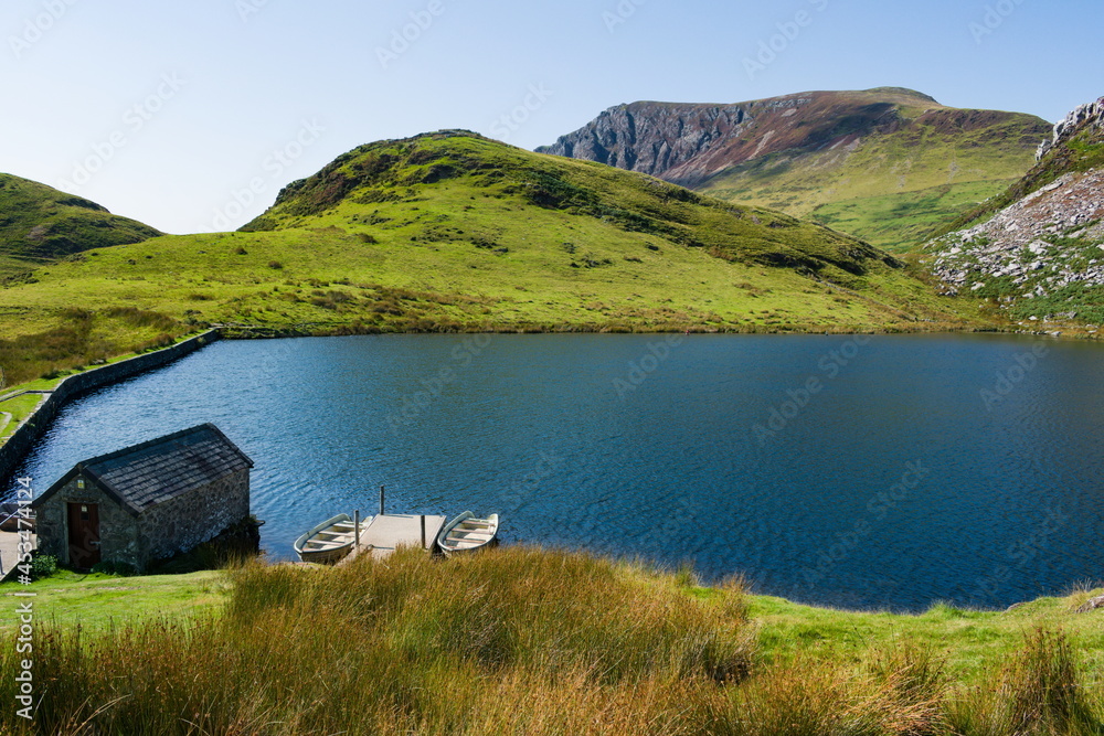 Beautiful mountain landscape, Snowdonia, Wales. High angle view of lake Dywarchen high in the hills of the Snowdon peaks. Dramatic scene on a summers day.  Blue sky and copy space