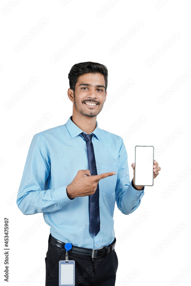 Young indian officer or student showing smartphone screen on white background. Young indian officer or student showing smartphone screen on white background.