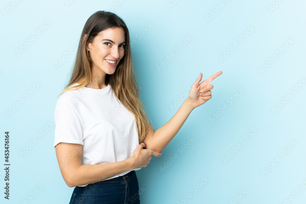 Young caucasian woman over isolated background pointing finger to the side Young caucasian woman over isolated background pointing finger to the side