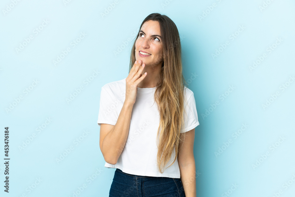 Young caucasian woman over isolated background looking up while smiling Young caucasian woman over isolated background looking up while smiling