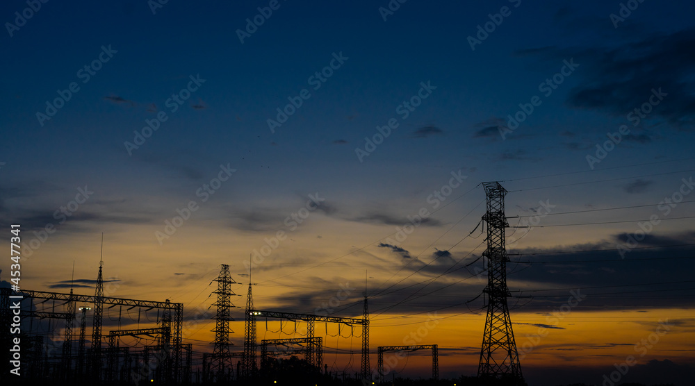 Sun setting over an electrical substation.