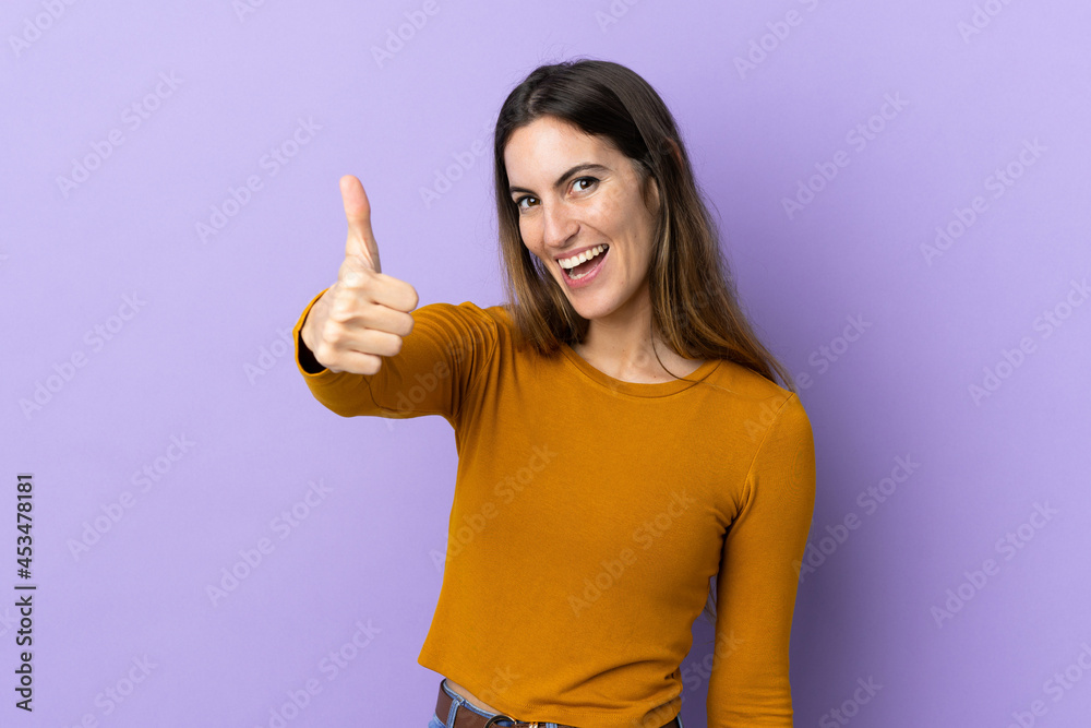 Young caucasian woman over isolated background with thumbs up because something good has happened Young caucasian woman over isolated background with thumbs up because something good has happened