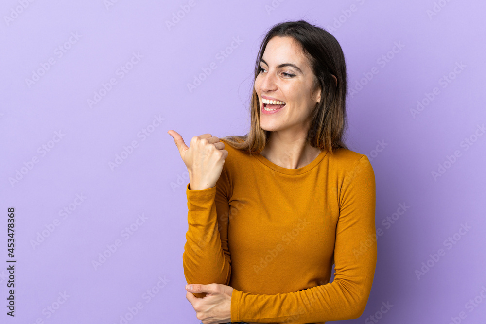 Young caucasian woman over isolated background pointing to the side to present a product