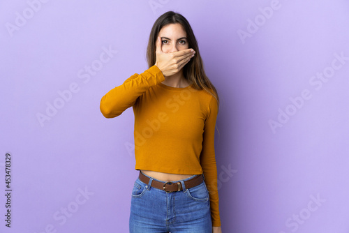 Young caucasian woman over isolated background covering mouth with hand