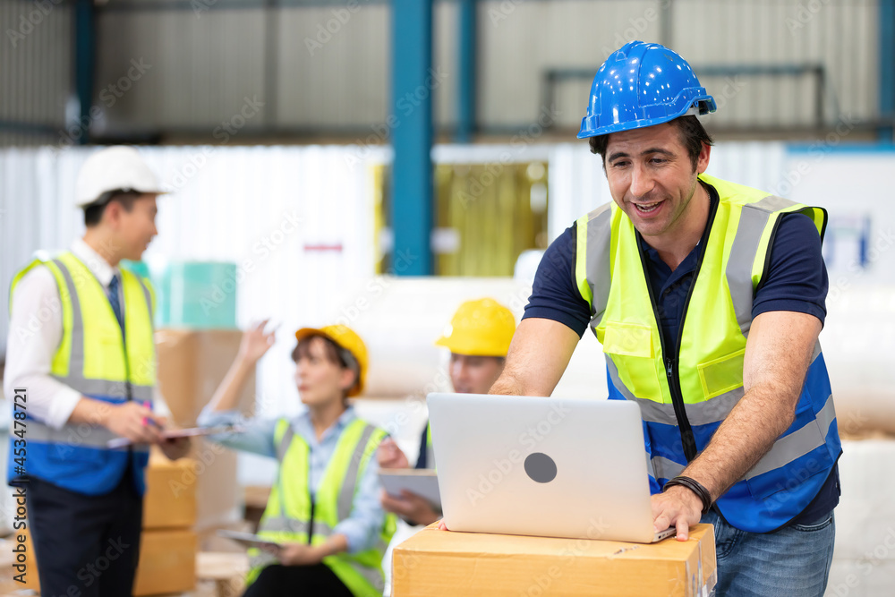 engineer or factory worker using laptop computer and talking to someone engineer or factory worker using laptop computer and talking to someone