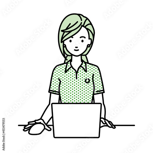 デスクで座ってPCを使っているポロシャツの女性