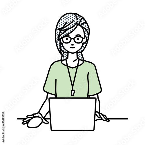 デスクで座ってPCを使っている教師の女性