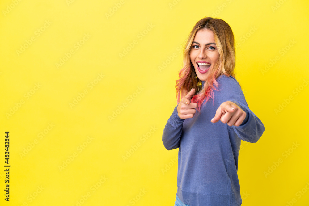 Young woman over isolated yellow background pointing to the front and smiling Young woman over isolated yellow background pointing to the front and smiling
