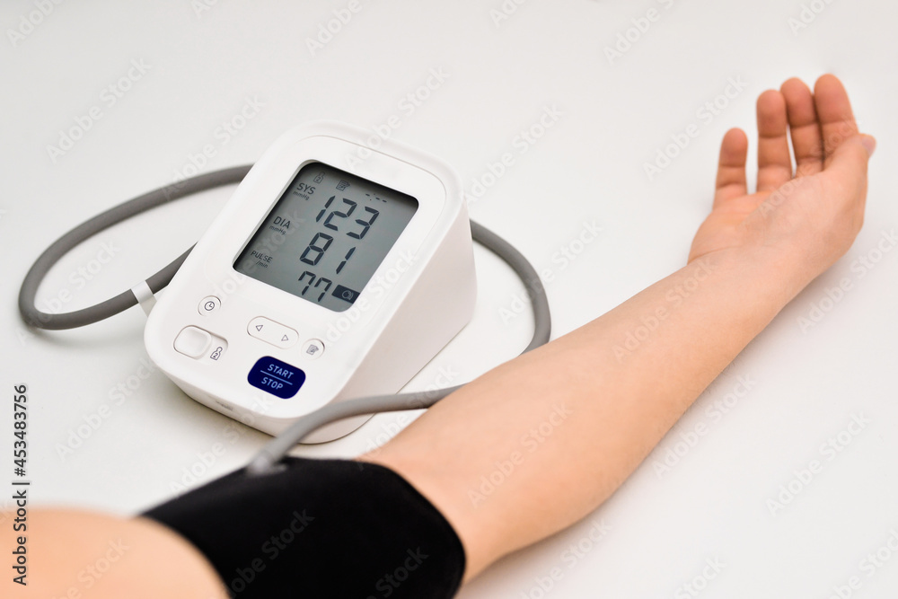 Woman check blood pressure monitor and heart rate monitor with digital pressure gauge. Healthcare and Medical concepts Woman check blood pressure monitor and heart rate monitor with digital pressure gauge. Healthcare and Medical concepts