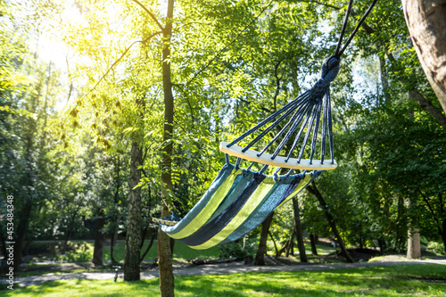 Colorful hammock for relaxing in a sunny park.