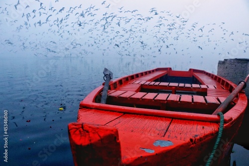 Early morning at yamuna ghat with a colorfull boat and blue water photo