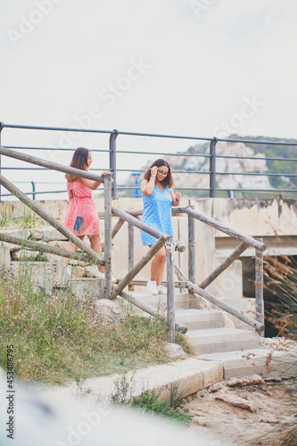 Two young women walking down stairs in Port d'Andratx, Spain