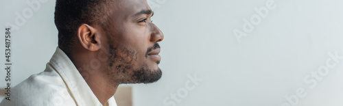 side view of pensive young african american man looking away, banner