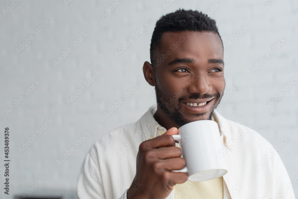 happy african american man holding cup of coffee in morning happy african american man holding cup of coffee in morning