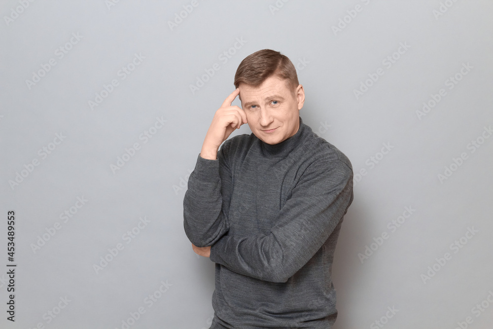 Portrait of happy mature man touching temple with hand and smiling Portrait of happy mature man touching temple with hand and smiling