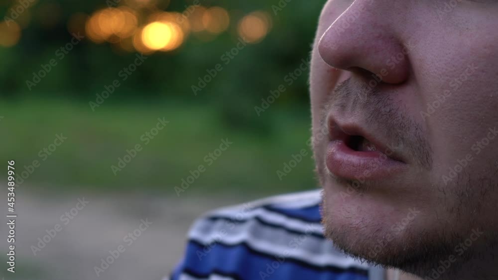 a man smokes a cigarette at sunset