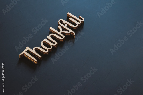 The word Thankful on a black background with copy space