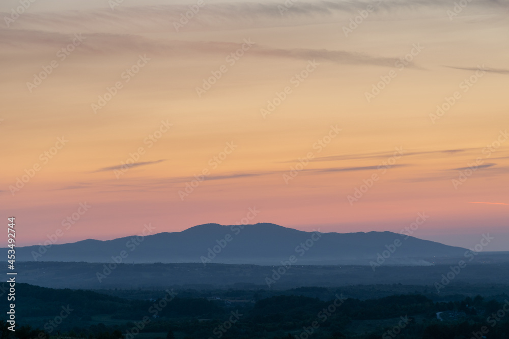 Mountain in haze and beautiful vivid colors in sky at dusk Mountain in haze and beautiful vivid colors in sky at dusk