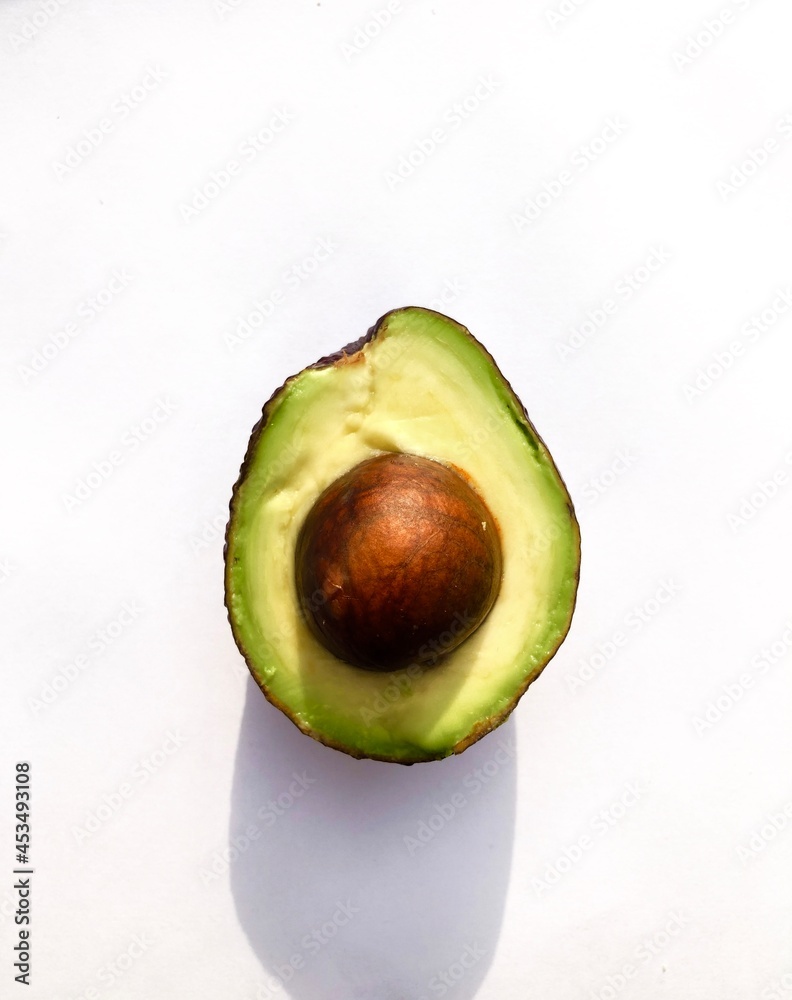 Juicy avocado with bone. Photo of an isolated avocado on a white background. Intense color of ripe natural avocado.