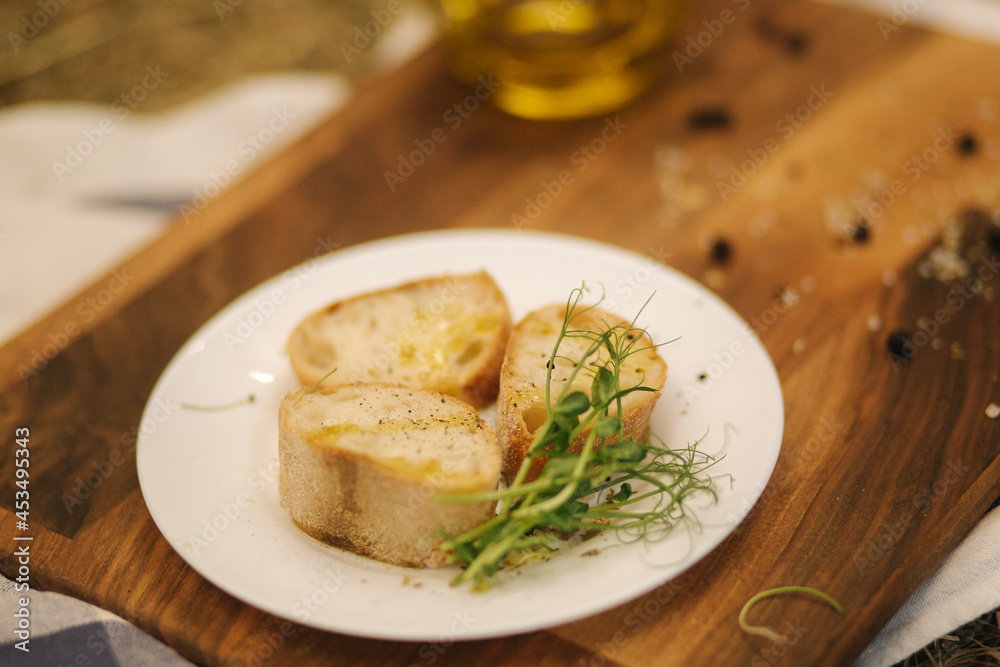 Healthy vegan breakfast concept. Whole wheat bread with olive oil. Sliced baguette on wooden table. Hay Healthy vegan breakfast concept. Whole wheat bread with olive oil. Sliced baguette on wooden table. Hay