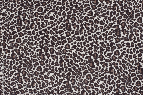 Fabric background with a print of the skin of a wild animal - leopard, cheetah. In clothes with a leopard print, a person feels brave and strong
