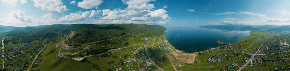 Fototapeta premium Panoramic view of Lake Baikal and serpentine road - aerial view of natural mountain valley with serpantine road, Trans-Siberian Highway, Russia, Kultuk, Slyudyanka. Panoramic view.