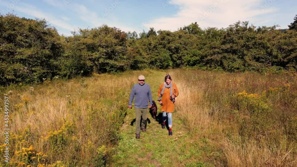 A mature couple talking a walk in the country on a lovely autumn day. A mature couple talking a walk in the country on a lovely autumn day.