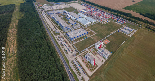 Modern exterior of industrial complex at daytime. Aerial view of manufacturing structure with parking for machinery outdoors. Industrial concept.