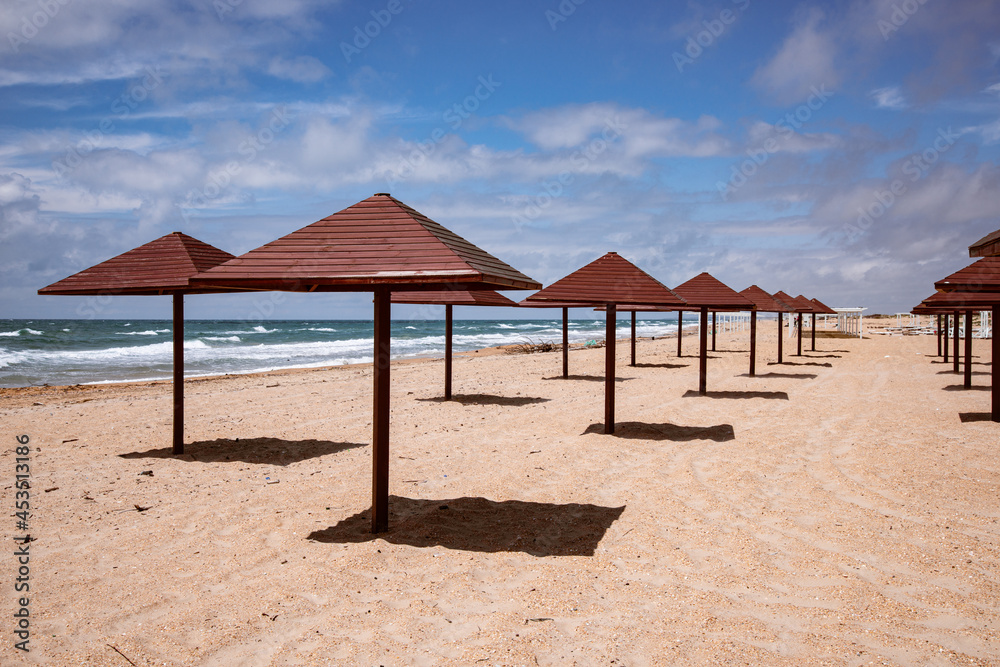 A beautiful sandy beach with an umbrella that casts a harmonious shade. A beautiful sandy beach with an umbrella that casts a harmonious shade.