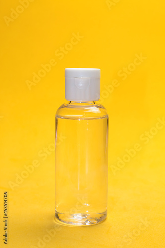 Bote de gel hidroalcoholico con fondo amarillo vertical para la desinfección de manos, protección ante el coronavirus. photo