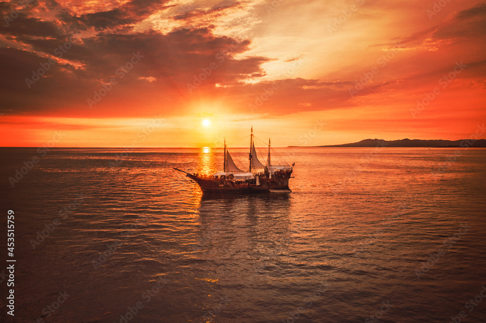 Pirate boat with a beautiful sunset as the background, the boat name is Marigalante and Iconic ship at Puerto Vallarta