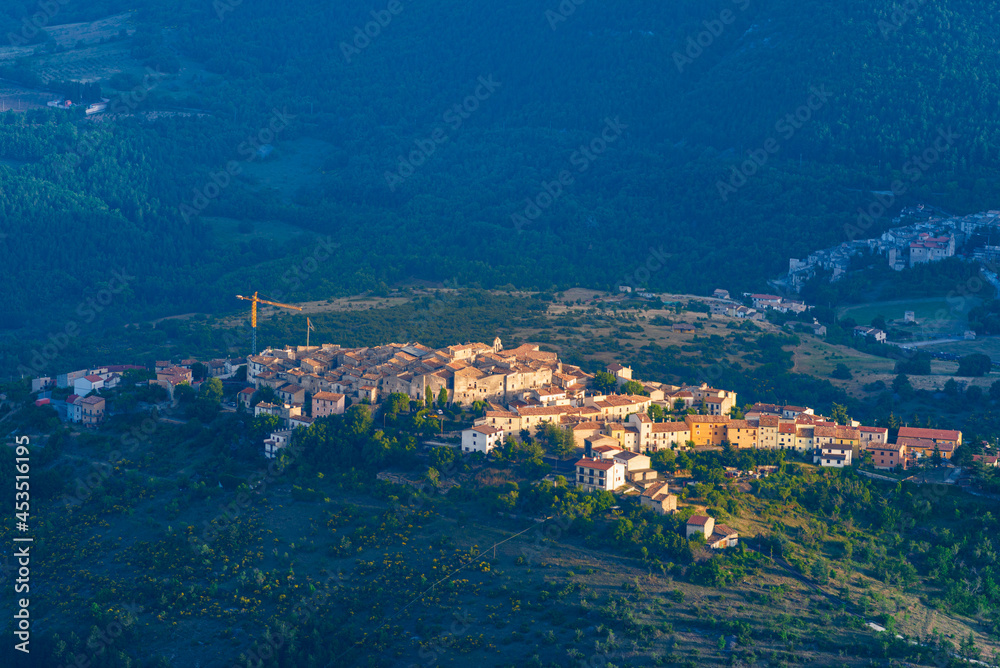 Sunset over medieval village perched on hill top, Abruzzo, Italy. Gran Sasso National Park, mountains landscape, tourism destination.