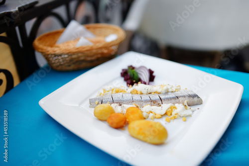 Traditional Lithuanian marinated herring served with sour cream, fresh vegetables and hot boiled potatoes.