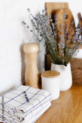 kitchen details, wooden tray with cutting board and ceramic jars on wooden table, white ceramic brick wall background. Sustainable living eco friendly kitchen.